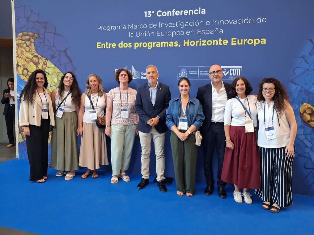 Image shows researchers lined up for photo at conference.